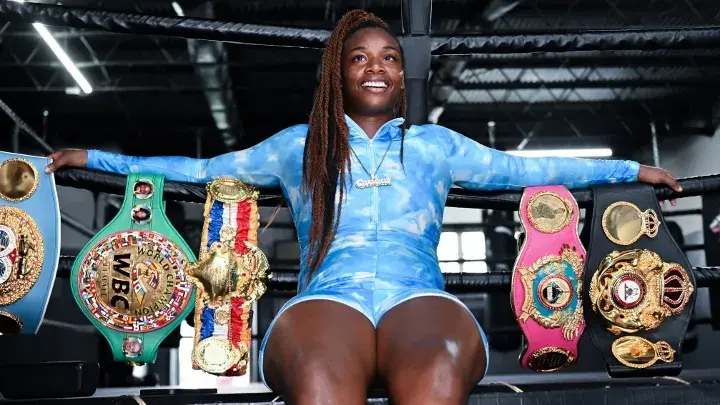 Claressa Shields seated alongside some of her many championship belts.