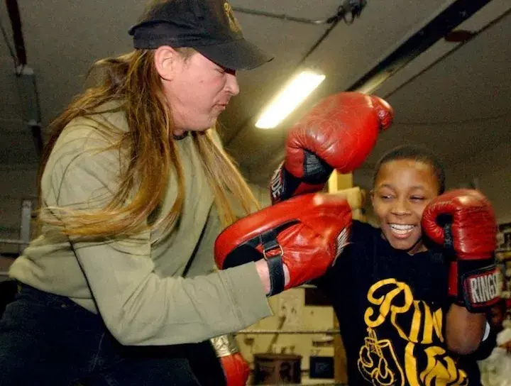 Brian Clark (left) holds mitts for a young Tramaine Williams in the boxing gym