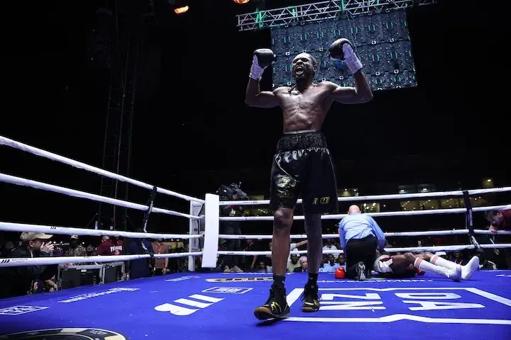Craig Richards raises his arms in celebration after stopping Dan Azeez in their boxing match on December 20, 2025.
