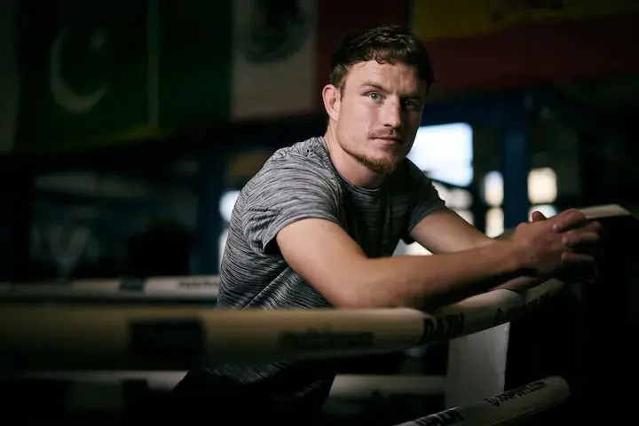 Junior welterweight Dalton Smith leans over the ropes of a boxing ring.