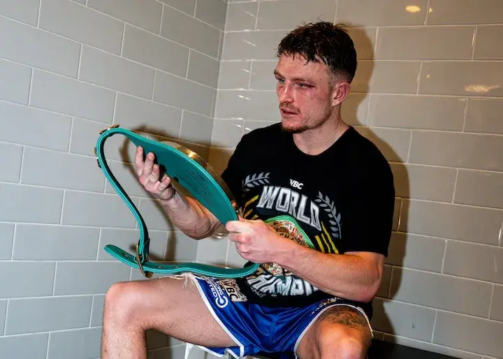 Dalton Smith looks down at the WBC junior welterweight world title soon after knocking out Subriel Matias to win the belt on January 10, 2026.