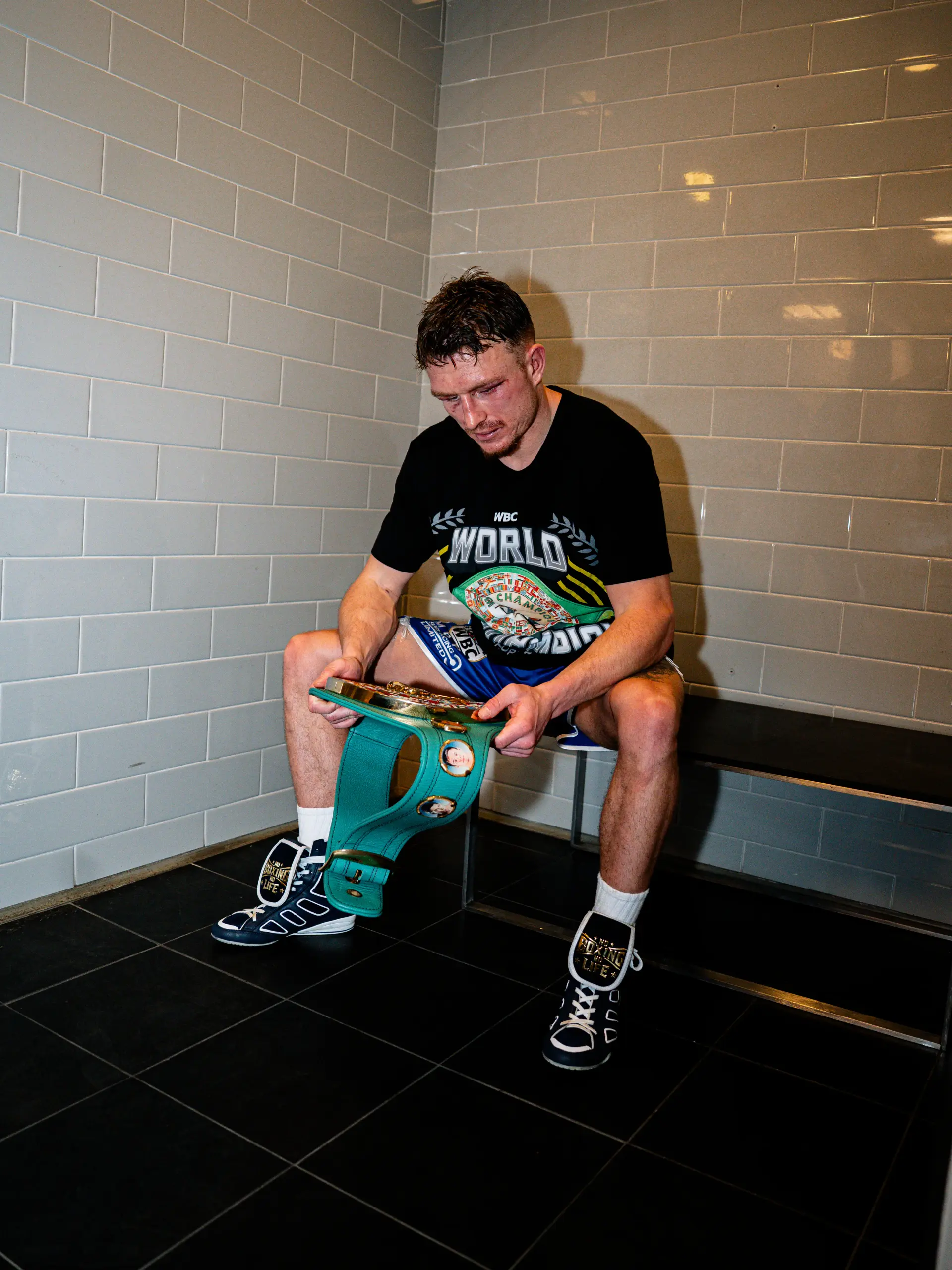 Dalton Smith looks down at the WBC junior welterweight world title soon after knocking out Subriel Matias to win the belt on January 10, 2026.