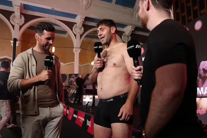 David Allen stands in his underwear, holding a microphone while being interviewed after weighing in on October 10, 2025, for his boxing match with Arslanbek Makhmudov.