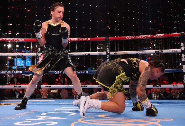 Elif Nur Turhan stands over a fallen Beatriz Ferreira on all fours during their boxing match on December 6, 2025.