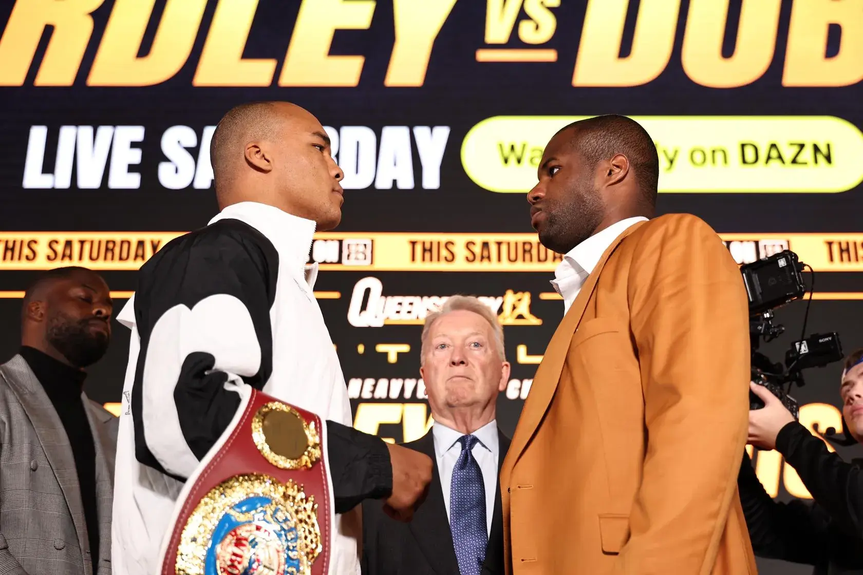 Fabio Wardley, holding his WBO heavyweight belt, locks eyes with Daniel Dubois on May 7, 2026