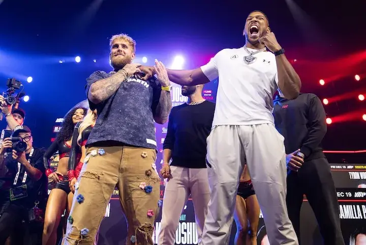 Jake Paul and Anthony Joshua pose for photos at a press conference on December 17, 2025, days before their boxing match.