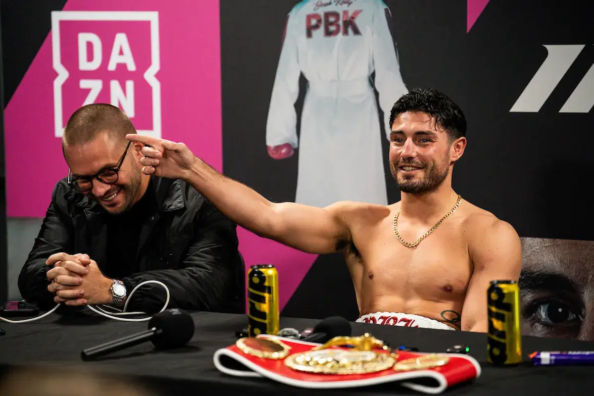 Josh Kelly celebrates his title win with Matchroom's Frank Smith
