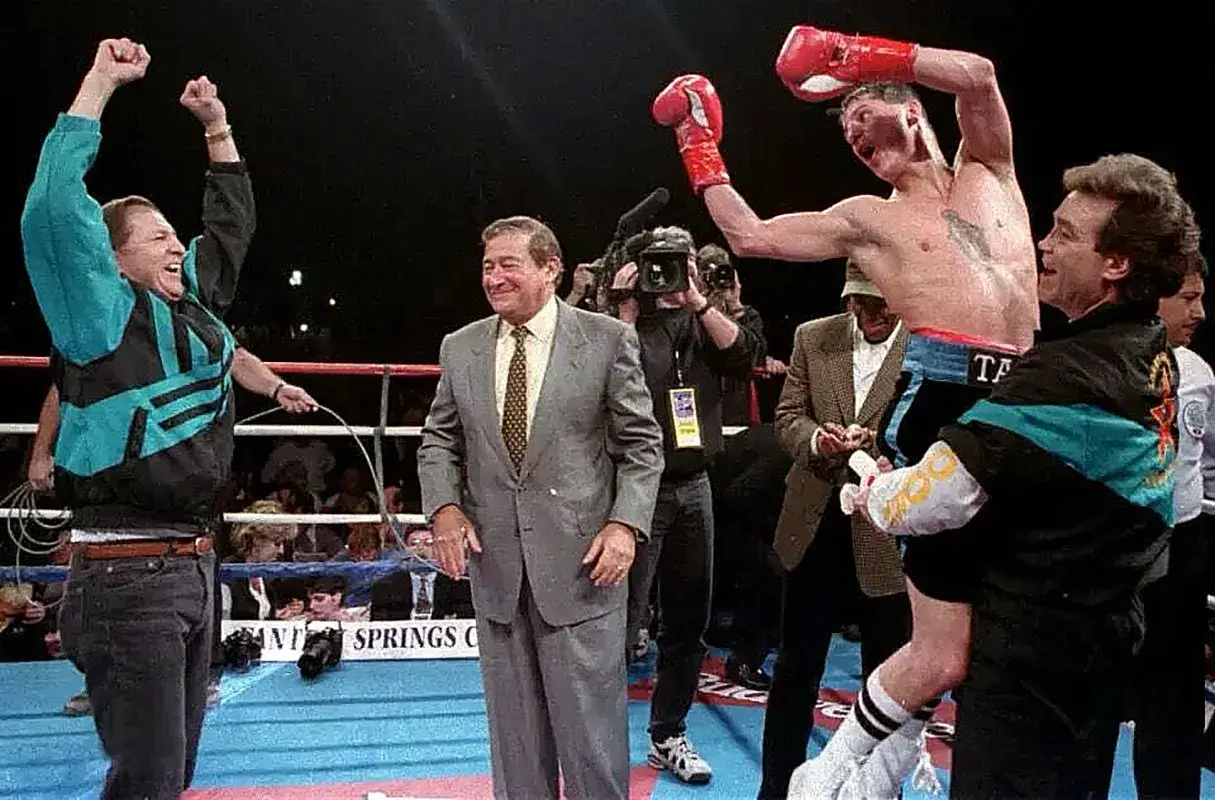 Trainer Larry Goossen lifts Johnny Tapia in victory with a joyous Bob Arum in the ring.