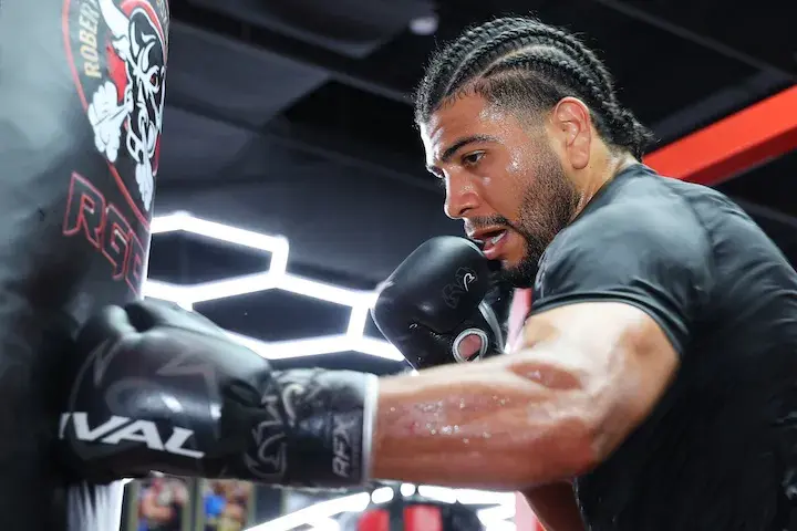 Raymond Muratalla punches a heavy bag with his left glove while in training camp