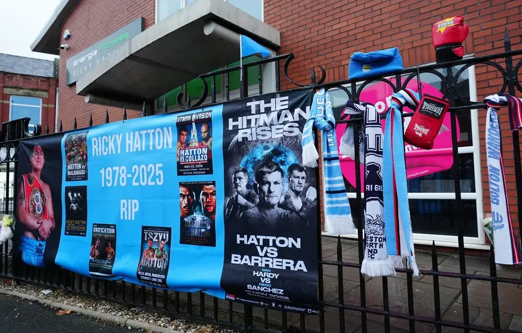 Posters and other items hang on a railing as a makeshift memorial for Ricky Hatton.
