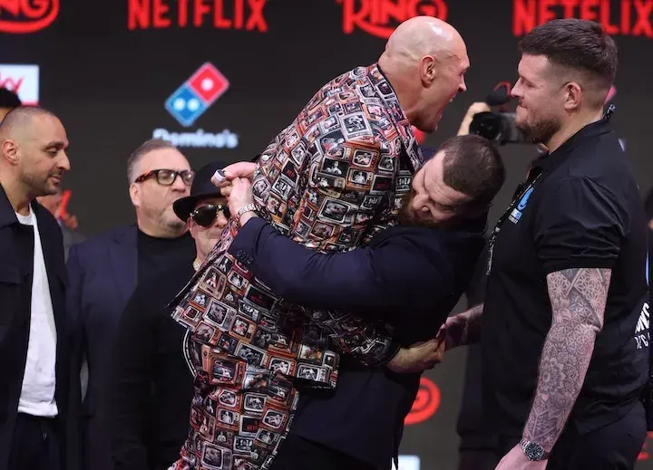 Arslanbek Makhmudov (right) lifts up Tyson Fury at the final press conference for their fight. (April 9, 2026)