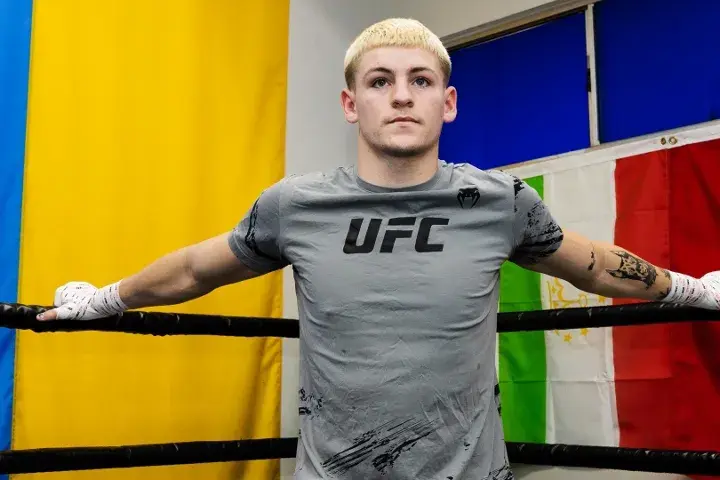 Callum Walsh stands in a boxing ring wearing a UFC shirt; he is supported by UFC head Dana White.