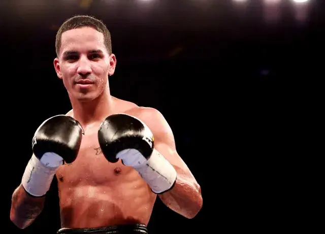 Emmanuel Rodriguez stands with gloves raised.