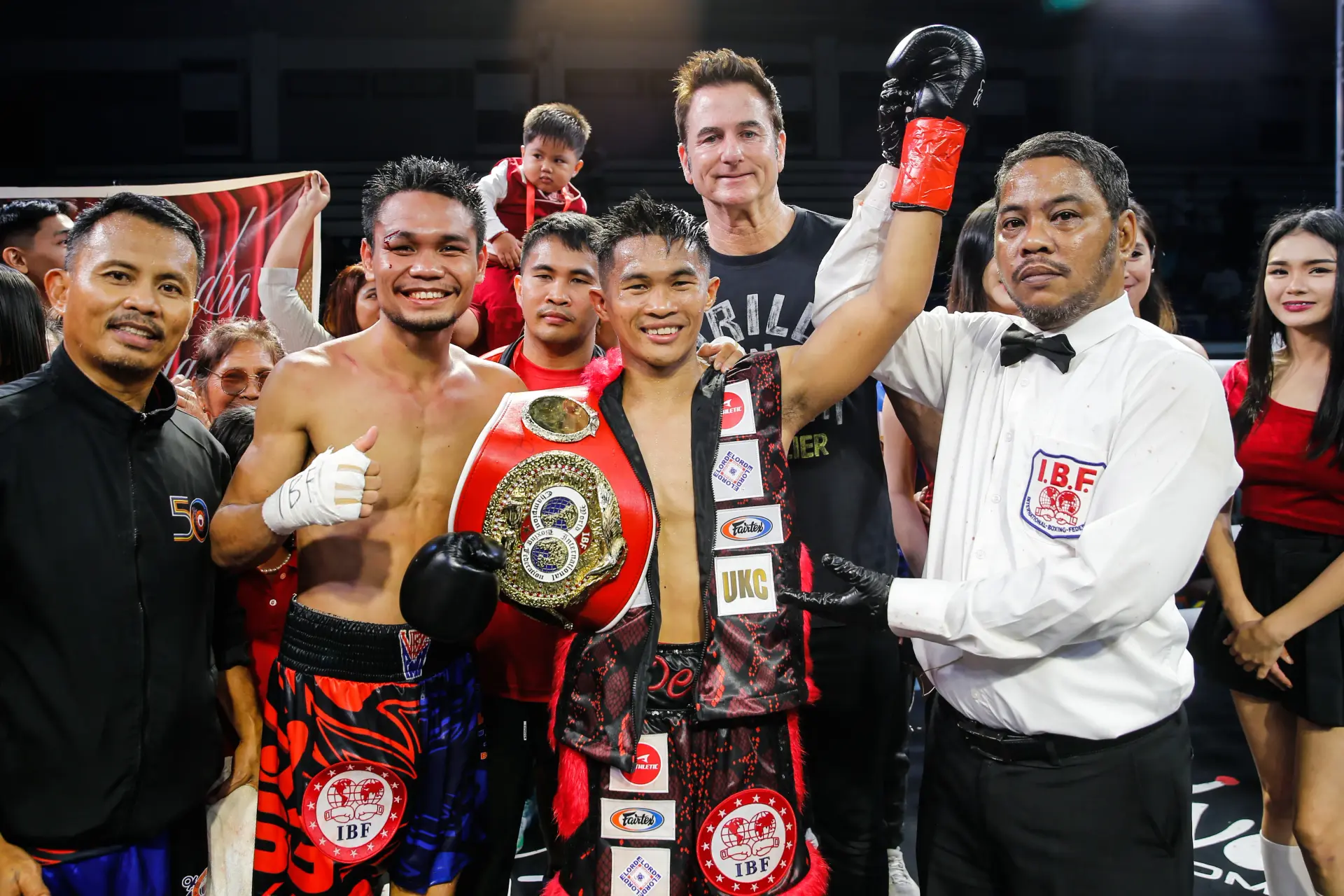 Referee Alfie Jocosol raises Pedro Taduran's hand in victory as he stands alongside Christian Balunan
