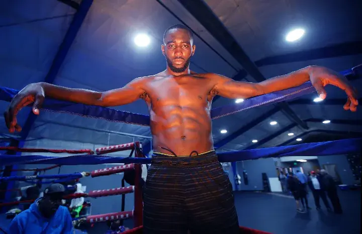 Terence Crawford poses for photos in a boxing ring.