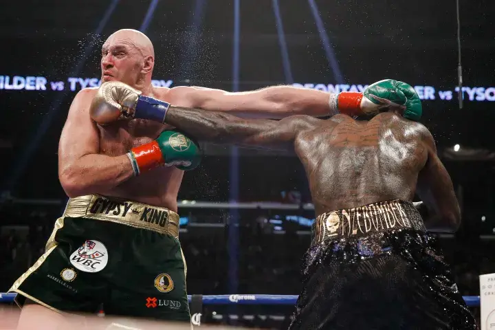 Tyson Fury takes a left hand from Deontay Wilder during their 2018 collision